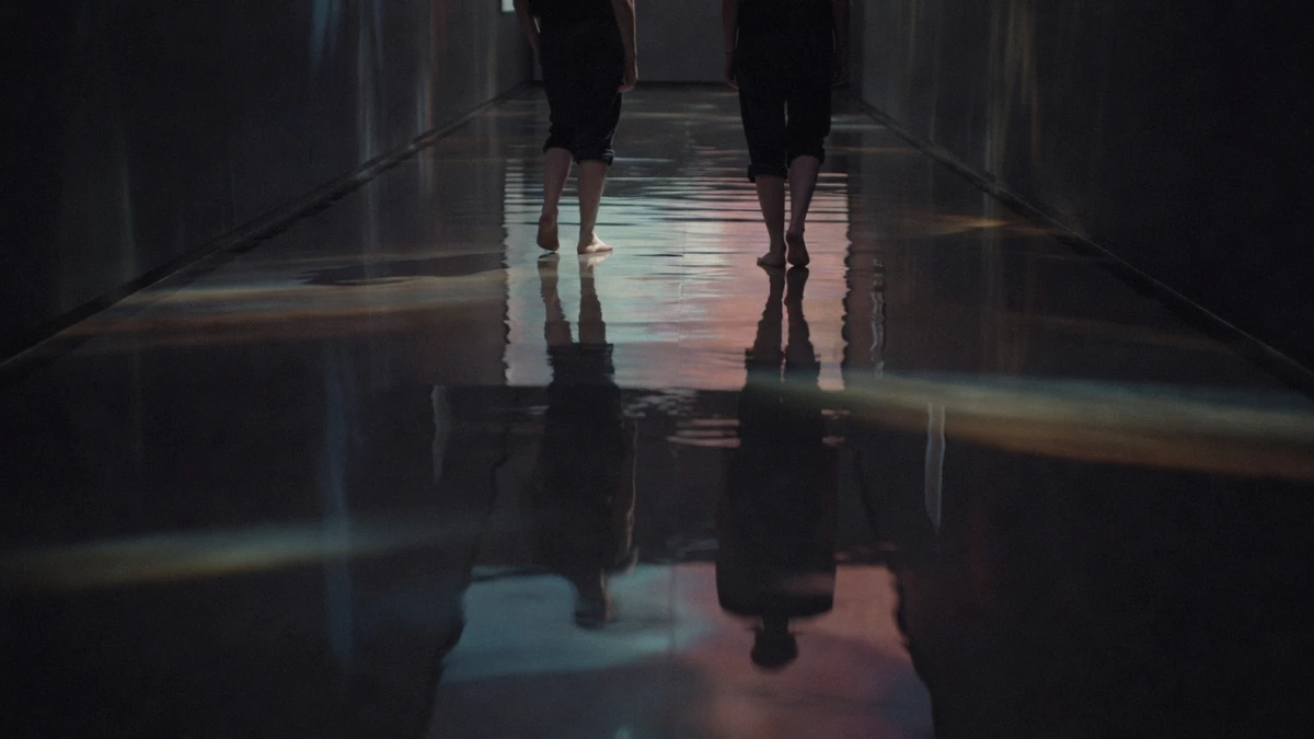 A mirrored hall of hanging light points inside a teamLab digital art museum in Tokyo, the Planets or Borderless decision seen from the maze side