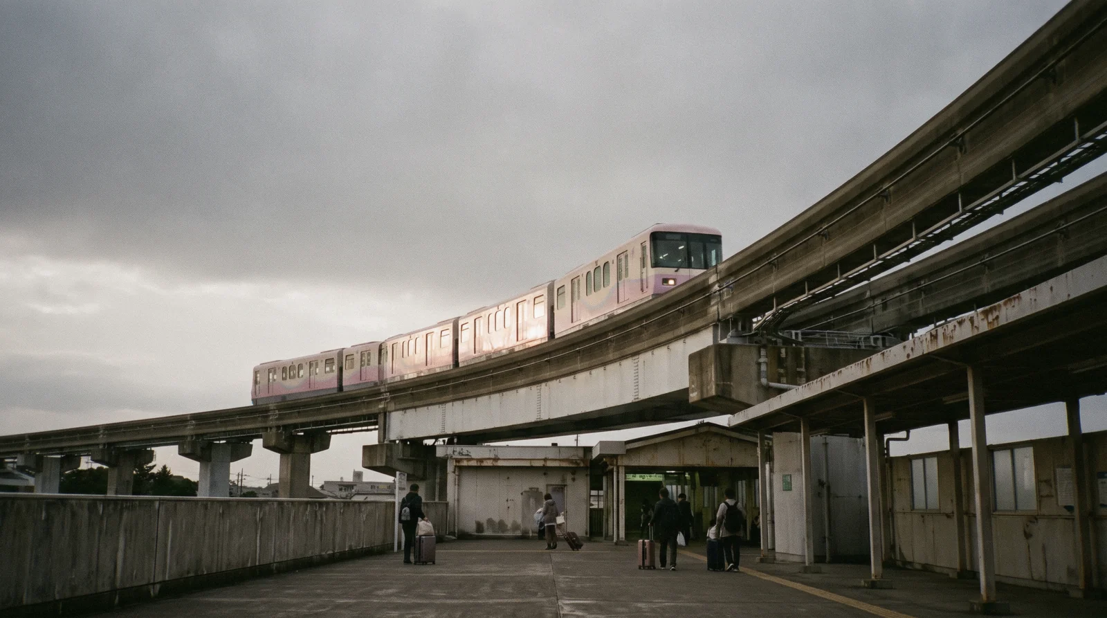 Monorail train crossing the water towards the two parks of Tokyo Disney Resort at Maihama in late afternoon light