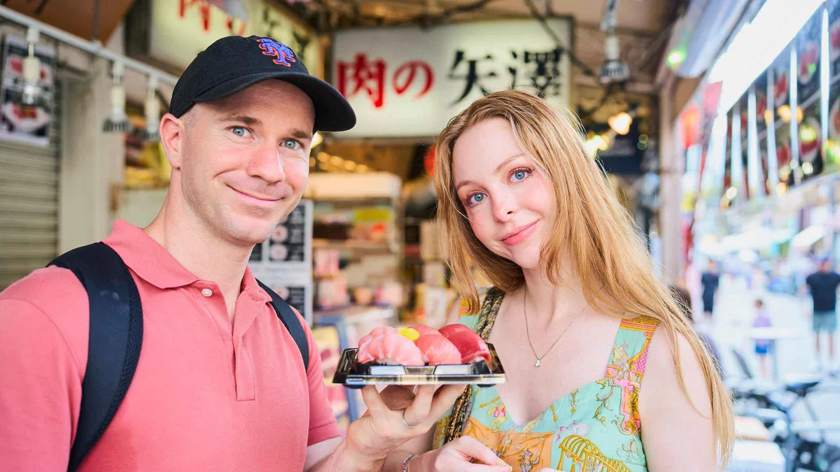 Local guide pointing out fresh tuna at a stall on a wheelchair-accessible Tsukiji Fish Market tour in Tokyo