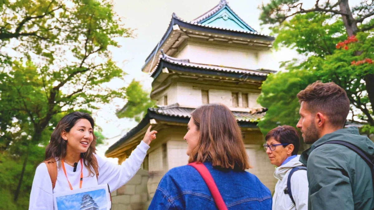 Small tour group listening to a guide beside Ninomaru Garden pond in the Imperial Palace East Gardens, Tokyo
