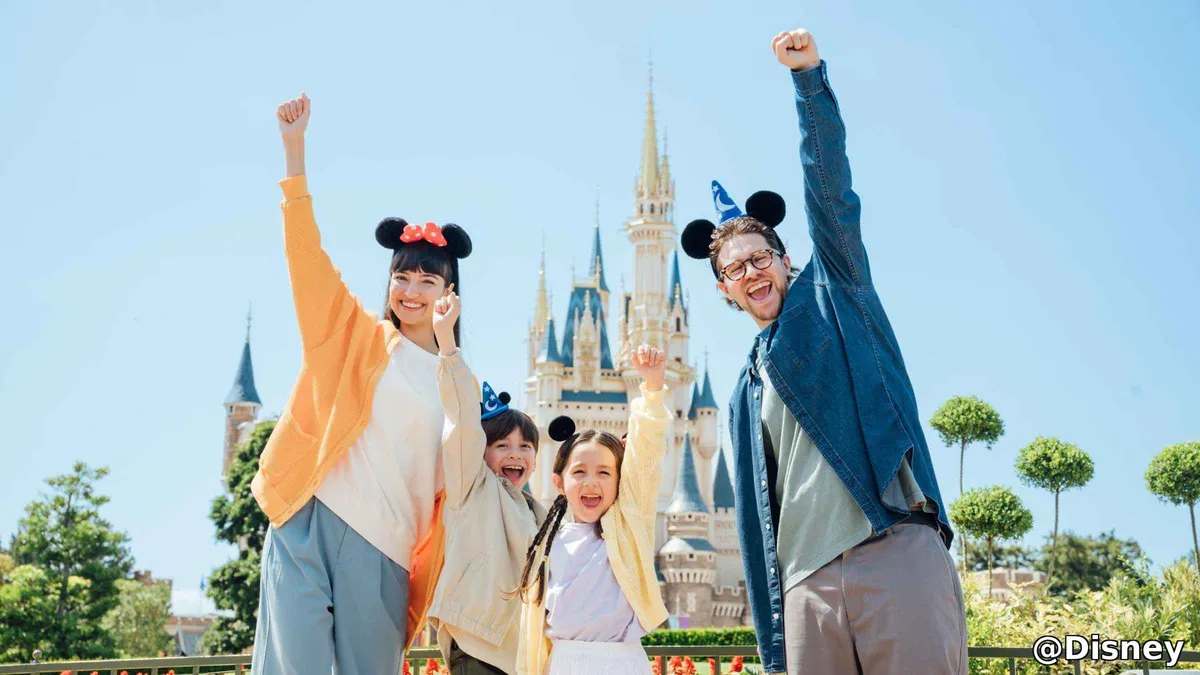 Families walking past castle-themed attractions on a Tokyo Disneyland 1-Day Passport ticket