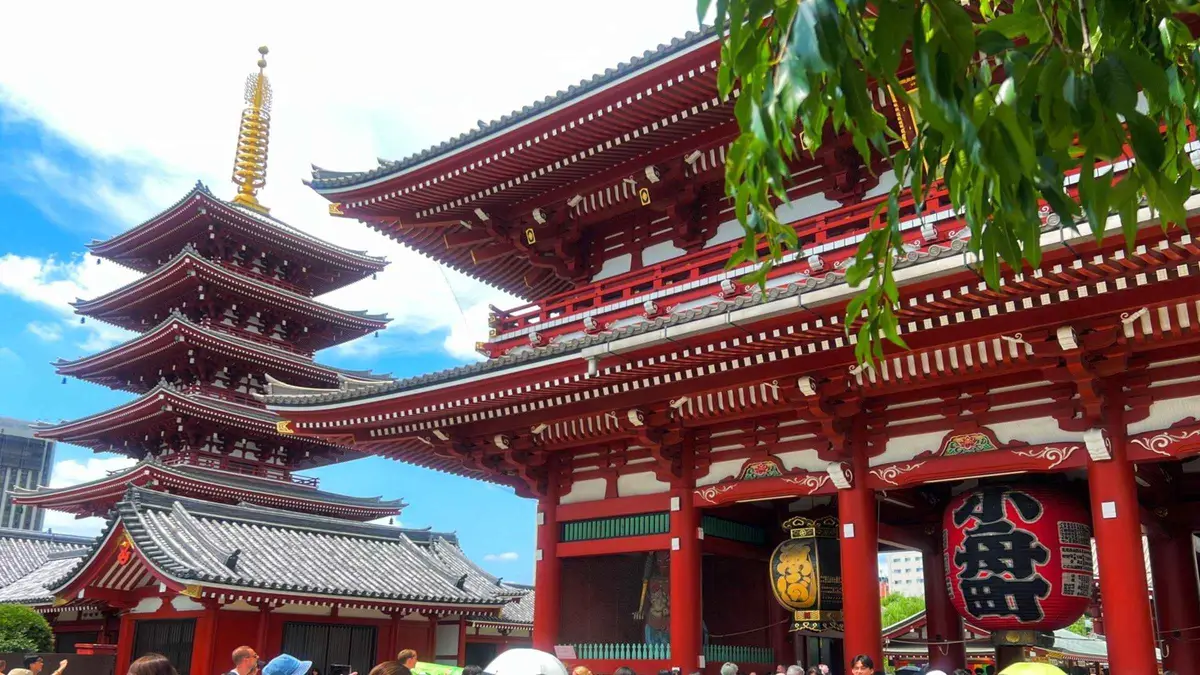 Small tour group walking down Nakamise Shopping Street toward Senso-ji Temple in Asakusa, Tokyo Japan